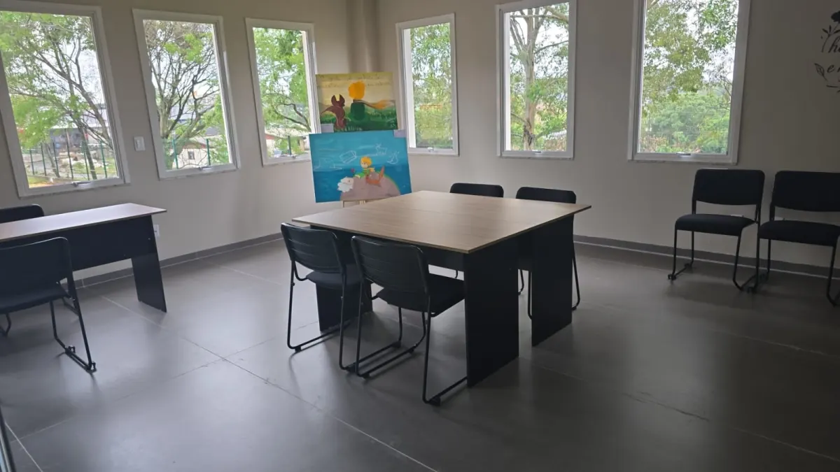 Sala de reunião com mesa quadrada e cadeiras de aproximação